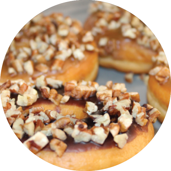 Bakery donut with chocolate frosting and nuts sprinkled on top